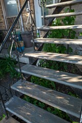 an abandoned wooden steps leading to a house with plants outside