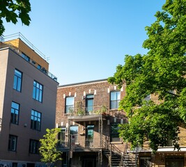 a few buildings next to some trees and a fire hydrant