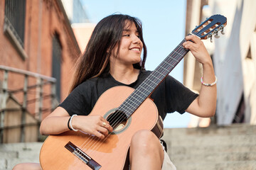 young woman musician playing classical guitar.