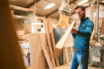 Carpenter Working In Woodwork Workshop Choosing Wood For Project