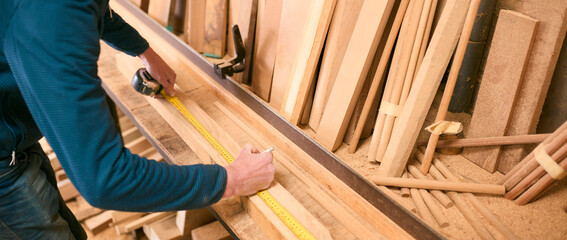 Close Up Of Carpenter Working In Woodwork Workshop Measuring Wood For Project