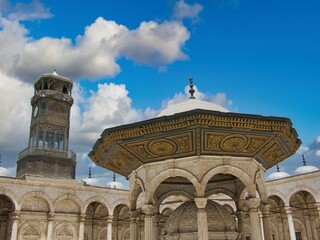 a fountain with a clock tower in the background on a sunny day
