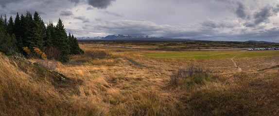 an empty grassy field is shown with the mountains in the background