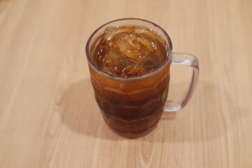 Ice tea in glass on wooden table. Selective focus and shallow depth of field.