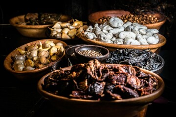 Array of wooden bowls overflowing with an assortment of various nuts, dried fruits, and spices