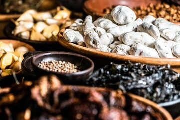 Array of wooden bowls overflowing with an assortment of various nuts, dried fruits, and spices