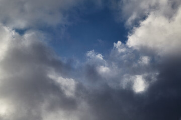 Obraz premium White clouds in the sky and between them you can see the blue sky, clouds high in the sky close-up, view of the sky through the clouds