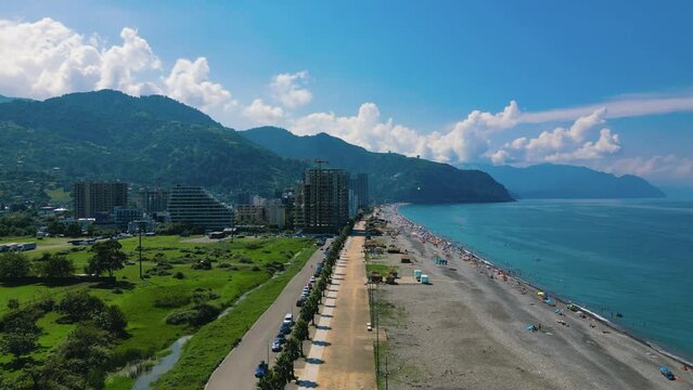 Drone footage of Gonio Beach and seafront buildings with mountains in the background, Gonio, Georgia