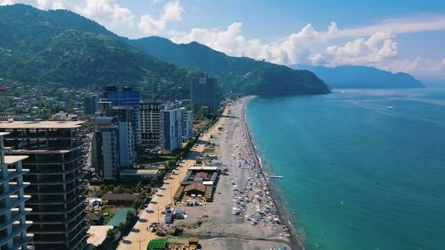 Drone footage of Gonio Beach and coastal buildings with mountains in the background, Gonio, Georgia