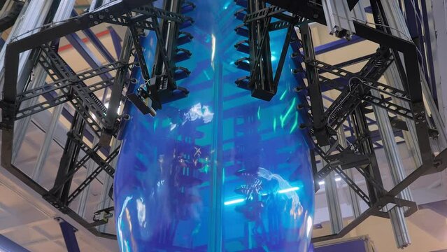 Bubble cage of blown plastic film extrusion machine at exhibition, trade show - the process of making blue plastic film. Manufacturing, recycling, production, and equipment concept