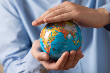 Close-up of man holding a globe in his hands. The concept of the individual's care for the planet's well-being.