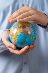 Close-up of man holding a globe in his hands. The concept of the individual's care for the planet's well-being.