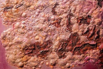Obraz premium Closeup of a rusty painted surface on a red car