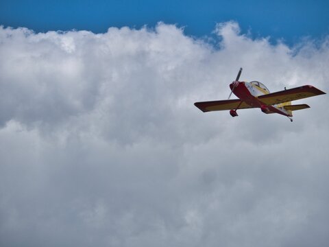 YAK 52 flying in a cloudy sky