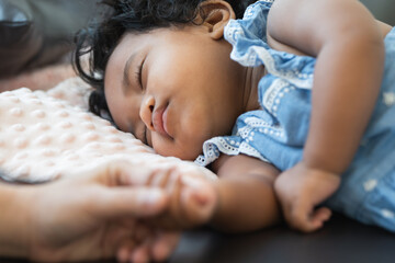 Cute African little newborn 7 months old baby girl with black curly hair  sleeping on sofa with...