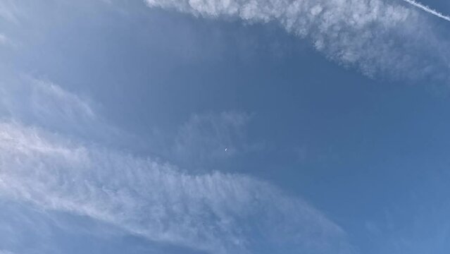 Low angle footage of the high level cirrus clouds in a blue sky on a sunny day