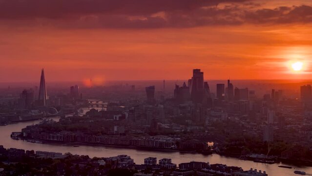 Fiery summer sunset time lapse view of the urban skyline of London, United Kingdom, with red colours and heat haze