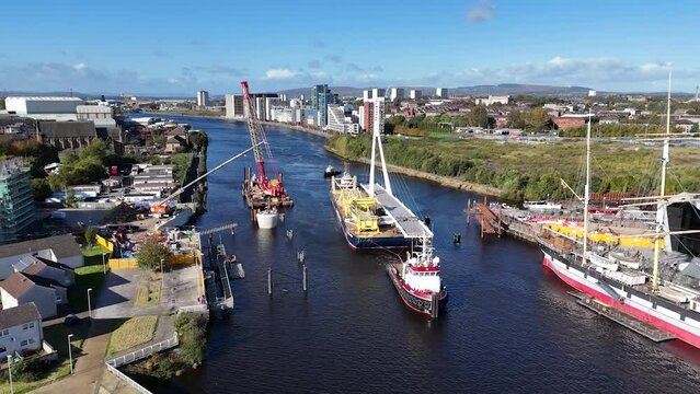 Drone footage of big barge travel on River Clyde in front of Riverside Museum in Glasgow, Scotland