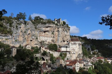 Cityscape on a cliff edge, with a backdrop of blue and white clouds in the sky