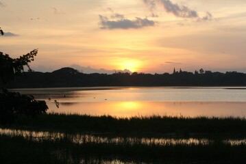 Stunning shot of a tranquil lake, with a backdrop of a warm and vibrant sunset in Mysore, India