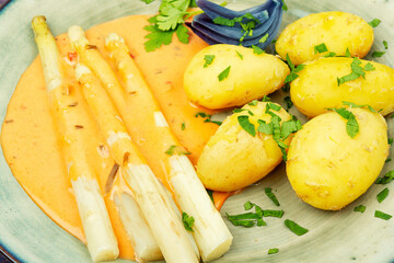 White boiled asparagus in sauce with potato