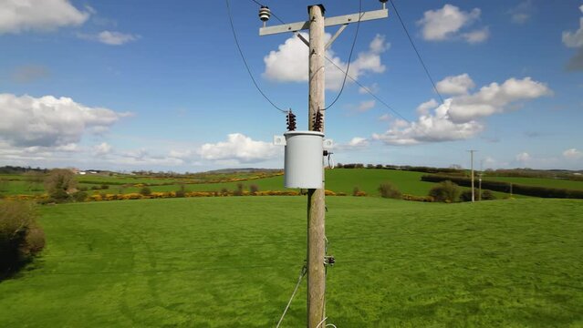 Drone shot circling a 15kVA electricity transformer on an electricity pole in a rural environment