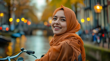 A woman in orange hijab smiling while riding a bike.