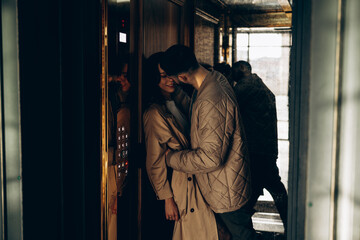 Happy young couple standing inside elevator cabin and embracing. © Stanislav
