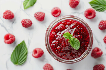Glass jar with raspberry jam and raspberries with leaves