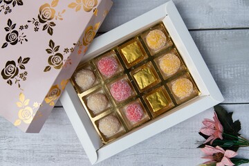 assorted treats are arranged in a pink box on a table