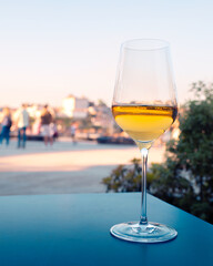 Glass of white port wine with the city of Porto in the background. Scene taken in the WOW district of Vila Nova de Gaia.