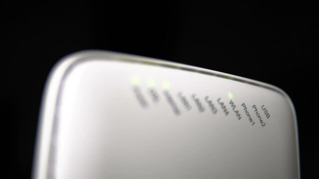 Correctly connected modem with flashing bulbs. The w-file works without problems. Connection. White modem, router on a black background. Technical support. place for text, monochrome background.