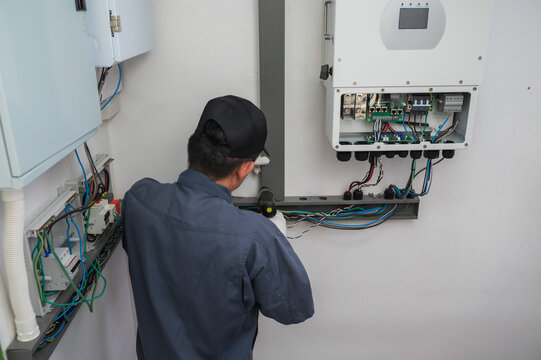 Professional solar engineer installing solar roof combiner box for home use