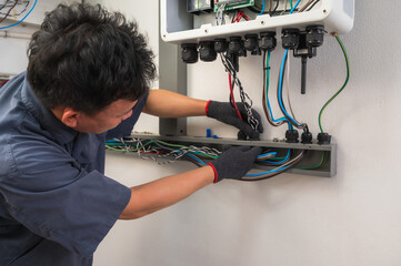 Professional solar engineer installing solar roof combiner box for home use