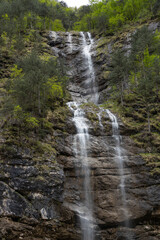 Obraz premium Rio di Repepeit. Wonderful waterfall that falls from a cliff. The force of the waterfall is a sight to behold. Hiking, trekking in the open area surrounded by woods. Summer holidays, peace.