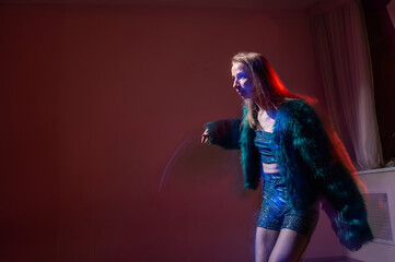 A young woman dances contemporary dances in blue and red light. Long exposure photo. 