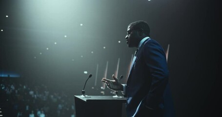 Anonymous Expert Standing Behind a Podium Stand, Giving a Compelling Presentation on Technology, Education and Leadership. Charismatic Black Motivational Speaker Coaching the Audience at a Conference