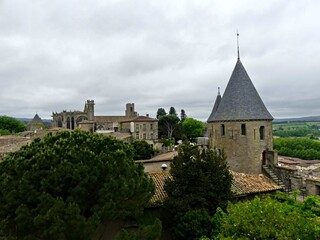 Fototapeta premium Carcassonne, May 2024: Visit the magnificent walled city of Carcassonne in Occitanie. Street photos - View of the fortified castle and ramparts protecting the historic town.