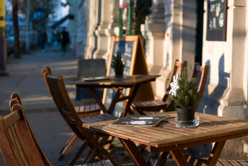 Table with winter decorations and chairs in a street cafe