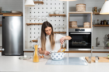 Cooking - Young woman with spaghetti on stove cooking Italian cuisine. University student or...