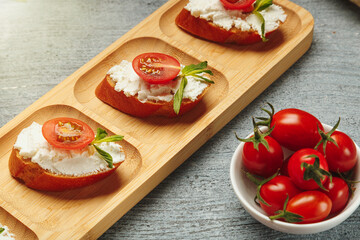 Bruschetta sandwiches with cottage cheese and tomato for lunch. A healthy snack for people on a special diet