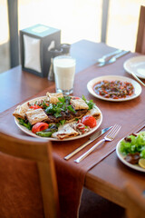 Traditional delicious Turkish foods; Lahmacun (Turkish pizza). Lahmacun traditional Turkish pizza and wraps with salad isolated on rustic wooden table.