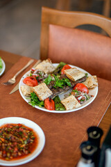 A tantalizing plate of Meat Kebab, French fries, kebabs, and fresh vegetables awaits a hungry diner. The fries are golden brown and crispy, the kebabs are tender and flavorful, and the vegetables