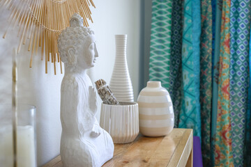 Shelf in a peaceful meditation studio with candles, statuary, and pottery for a soothing experience