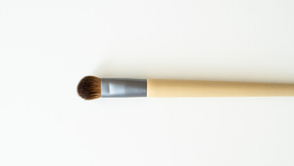 Wooden organic makeup brushes on white backdrop. Eco-friendly