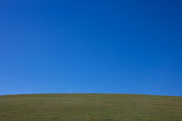 Green hill, field and sky