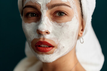 Portrait of a beautiful girl in the studio in a bathrobe and with cream on her face. Grain effect used