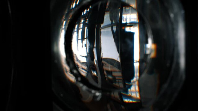 old glass of a lighthouse with the inverted reflection of the silhouette of a walking couple 60fps