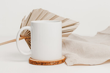 Mockup mug on wooden cup coaster with palm leaf and linen cloth. Mockup mug for logo, branding,...