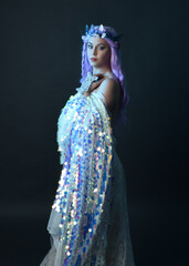 artistic portrait of beautiful female model with long purple hair wearing a fantasy fairy crown,...